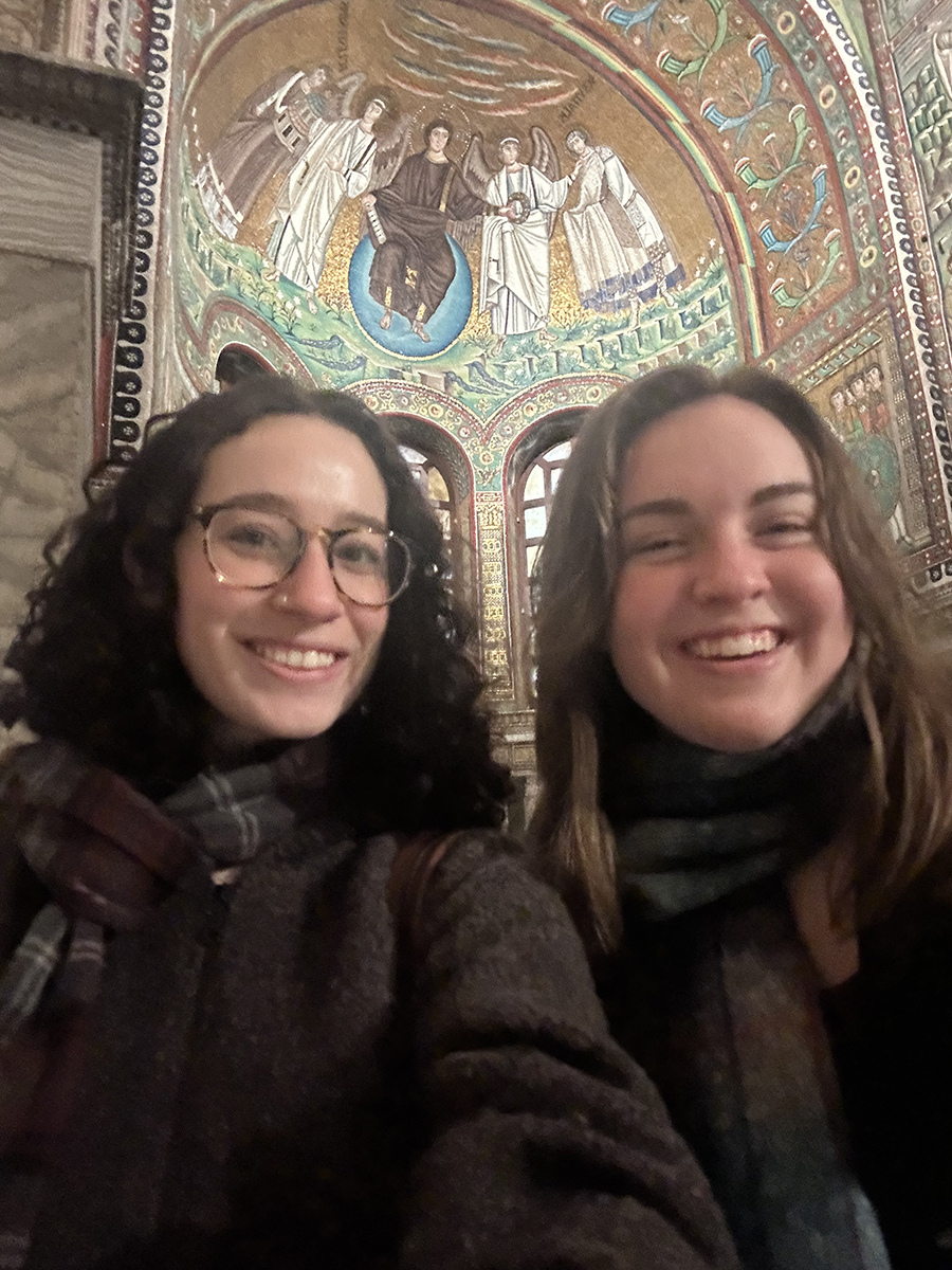 Two young women (Lily Hemmeter and Kathleen Quintana) in a selfie with apse mosaic of romanesque church (San Vitale) in background