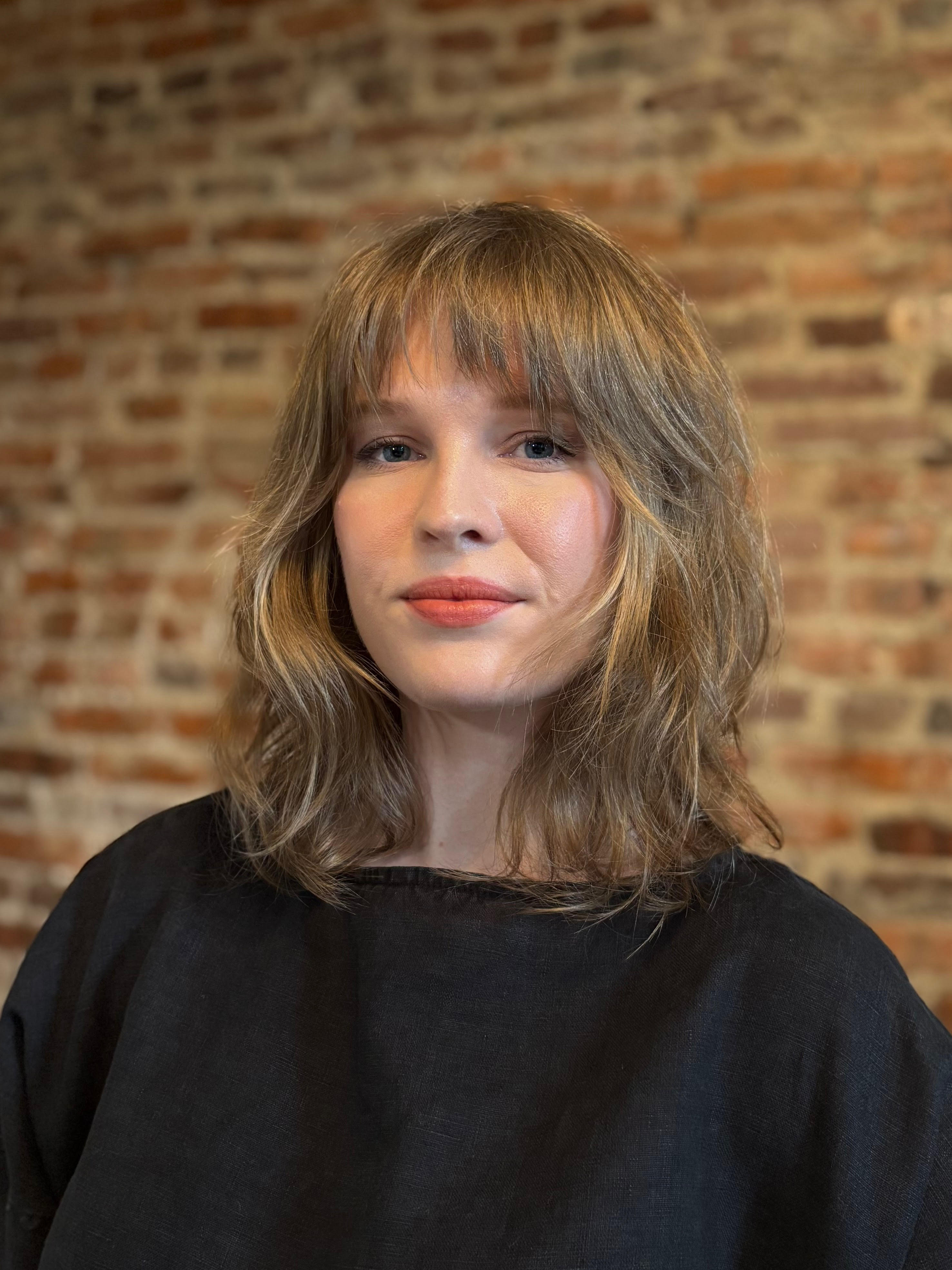 picture of Maura Callahan before a slightly out-of-focus brick wall